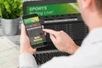 Utente che confronta quote e dati su una piattaforma di scommesse sportive da smartphone e computer
